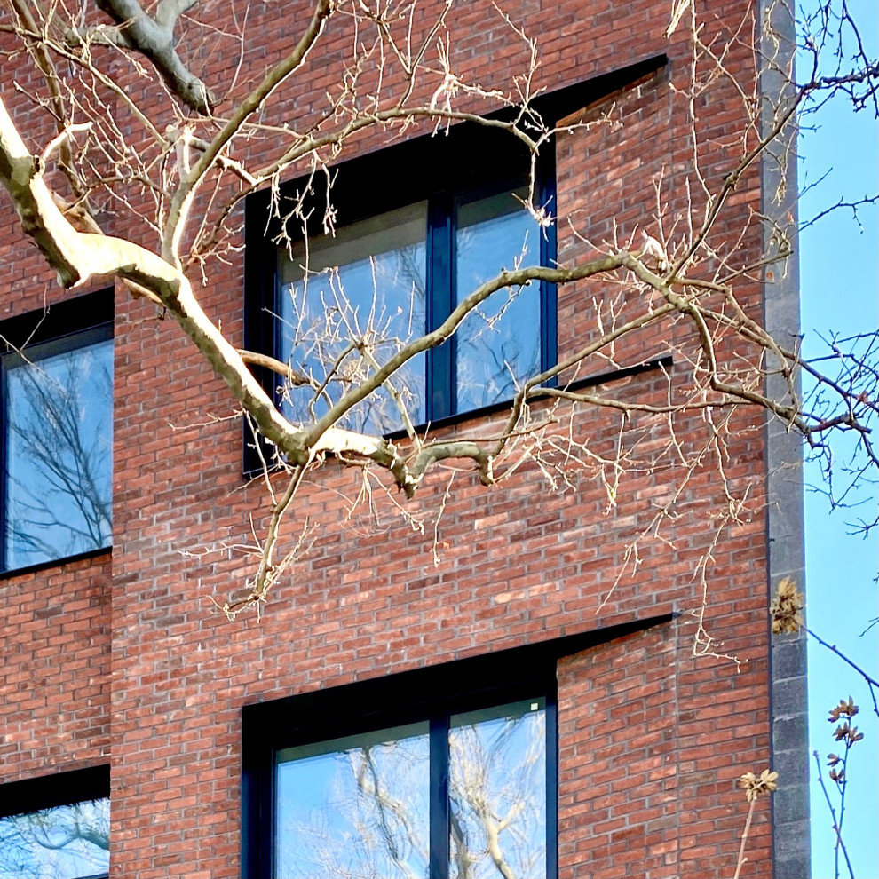 Inspiration for a modern brick townhouse exterior in New York with four or more storeys.