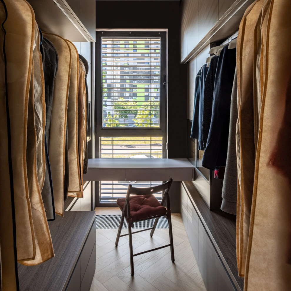 Photo of a large contemporary gender-neutral walk-in wardrobe in Moscow with open cabinets, medium wood cabinets and light hardwood floors.