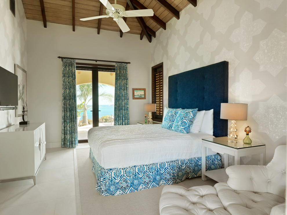 Design ideas for a mid-sized beach style loft-style bedroom in Other with beige walls and limestone floors.