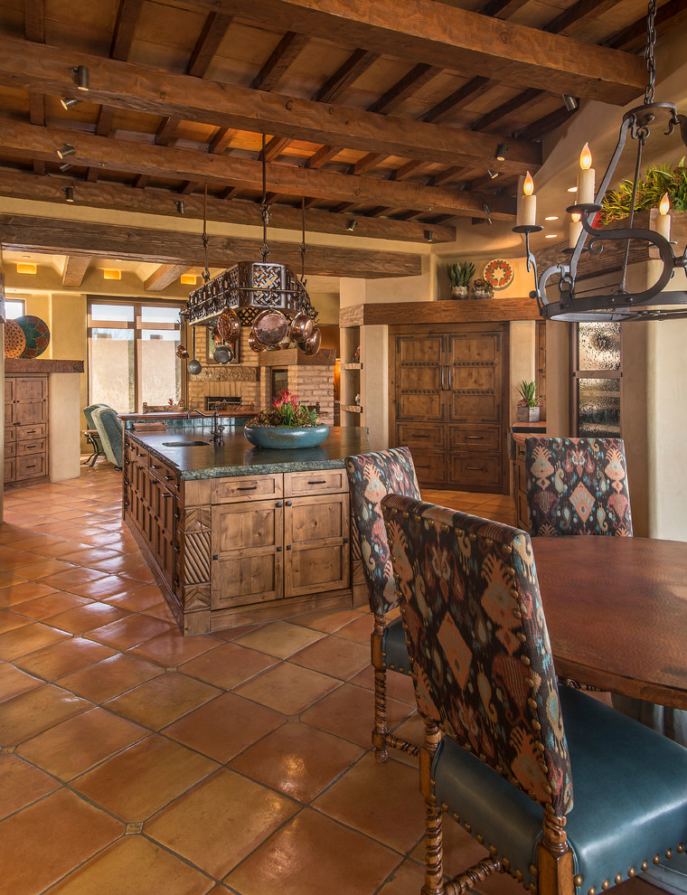 Photo of a large kitchen in Phoenix with flat-panel cabinets, distressed cabinets, solid surface benchtops, terra-cotta floors and with island.