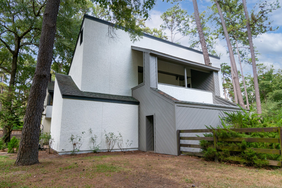 Geräumiges, Zweistöckiges Modernes Einfamilienhaus mit Faserzement-Fassade, grauer Fassadenfarbe, Satteldach, Schindeldach, schwarzem Dach und Verschalung in Houston