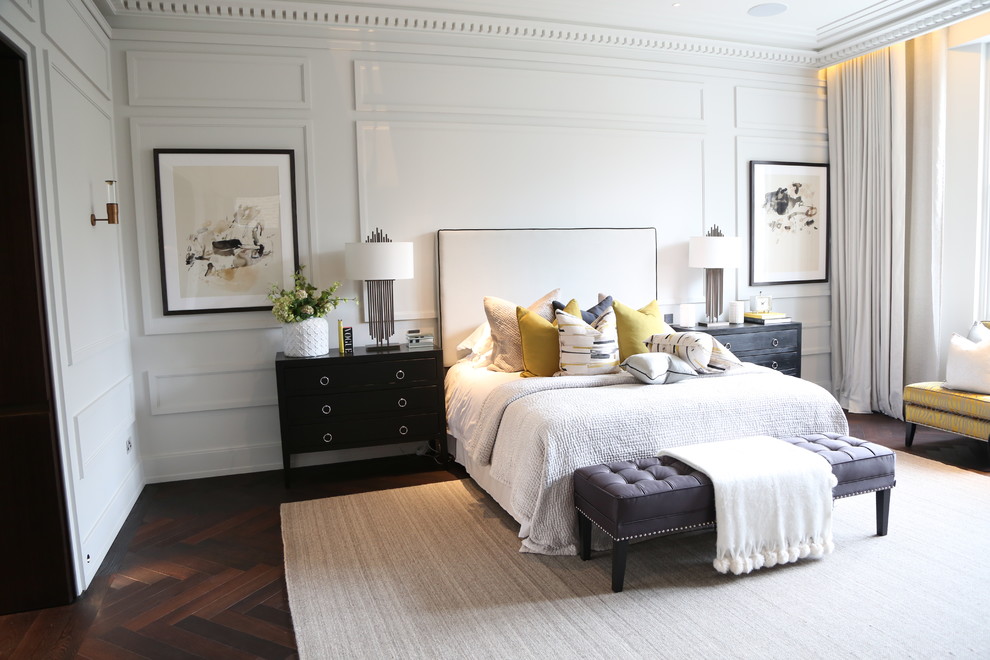 Traditional master bedroom in London with white walls and dark hardwood floors.