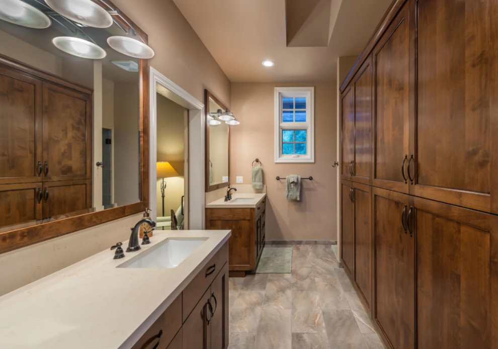 Large mountain style master porcelain tile and gray floor bathroom photo with recessed-panel cabinets, dark wood cabinets, beige walls, an undermount sink and quartz countertops