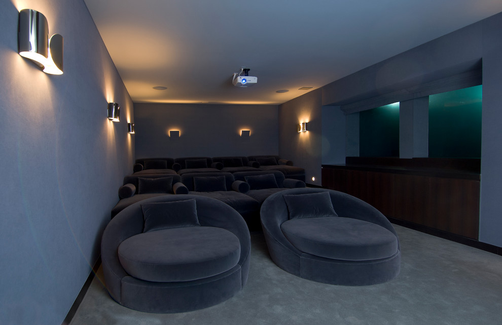 Large modern enclosed home theatre in Los Angeles with carpet and grey floor.