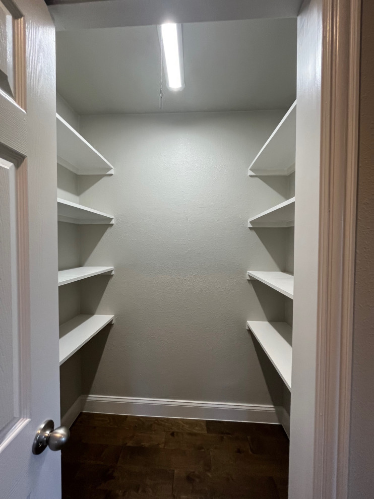 Example of a mid-sized transitional gender-neutral dark wood floor and brown floor walk-in closet design in Dallas with white cabinets