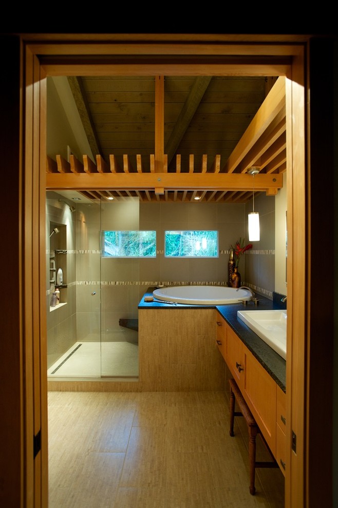 Inspiration for a mid-sized asian master bathroom in Seattle with a vessel sink, shaker cabinets, light wood cabinets, granite benchtops, a japanese tub, an open shower, a wall-mount toilet, gray tile, porcelain tile, beige walls and porcelain floors.