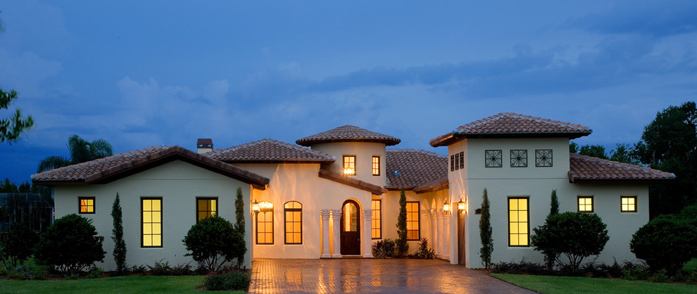 Inspiration for a mid-sized mediterranean one-storey stucco white exterior in Orlando with a hip roof.