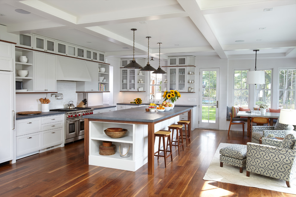 Inspiration for a beach style l-shaped open plan kitchen in Boston with shaker cabinets, white cabinets, white splashback, stainless steel appliances, medium hardwood floors and with island.