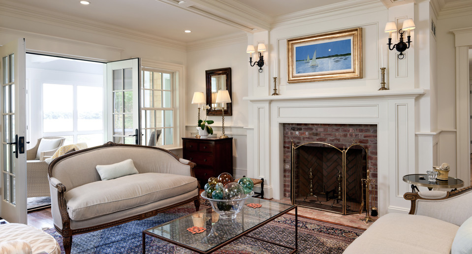 Large beach style enclosed living room in Boston with white walls, medium hardwood floors, a standard fireplace and a brick fireplace surround.