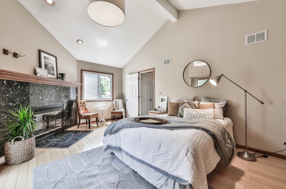 Photo of a mid-sized contemporary master bedroom in Chicago with beige walls, light hardwood floors, a corner fireplace and a stone fireplace surround.
