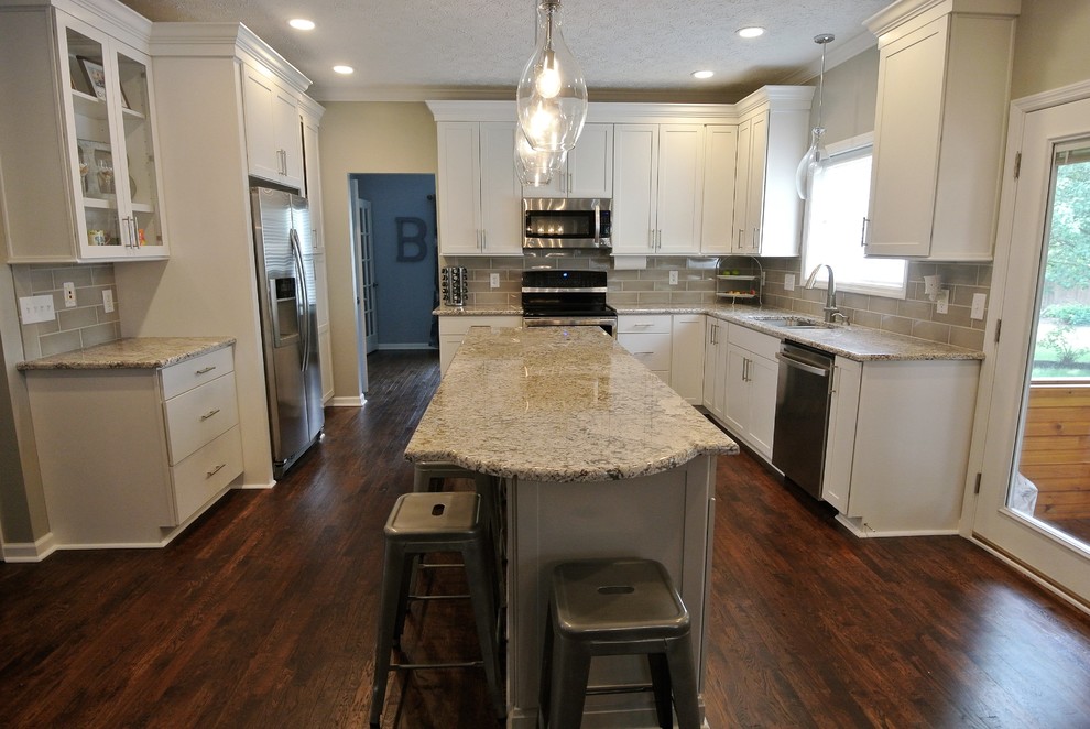 Eat-in kitchen - large transitional u-shaped dark wood floor eat-in kitchen idea in Indianapolis with an undermount sink, raised-panel cabinets, white cabinets, granite countertops, gray backsplash, ceramic backsplash, stainless steel appliances and an island