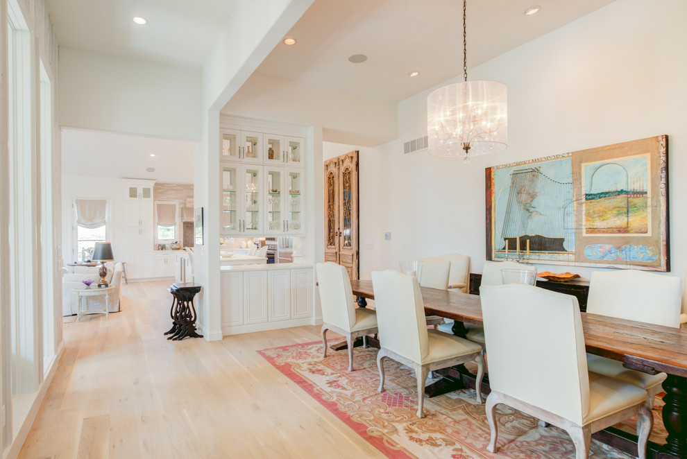 Photo of a traditional dining room in Denver with white walls and light hardwood floors.