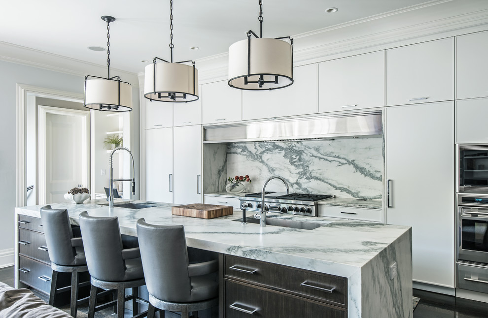 This is an example of a contemporary kitchen in Chicago with an undermount sink, flat-panel cabinets, white cabinets, marble benchtops, stainless steel appliances, with island and marble splashback.