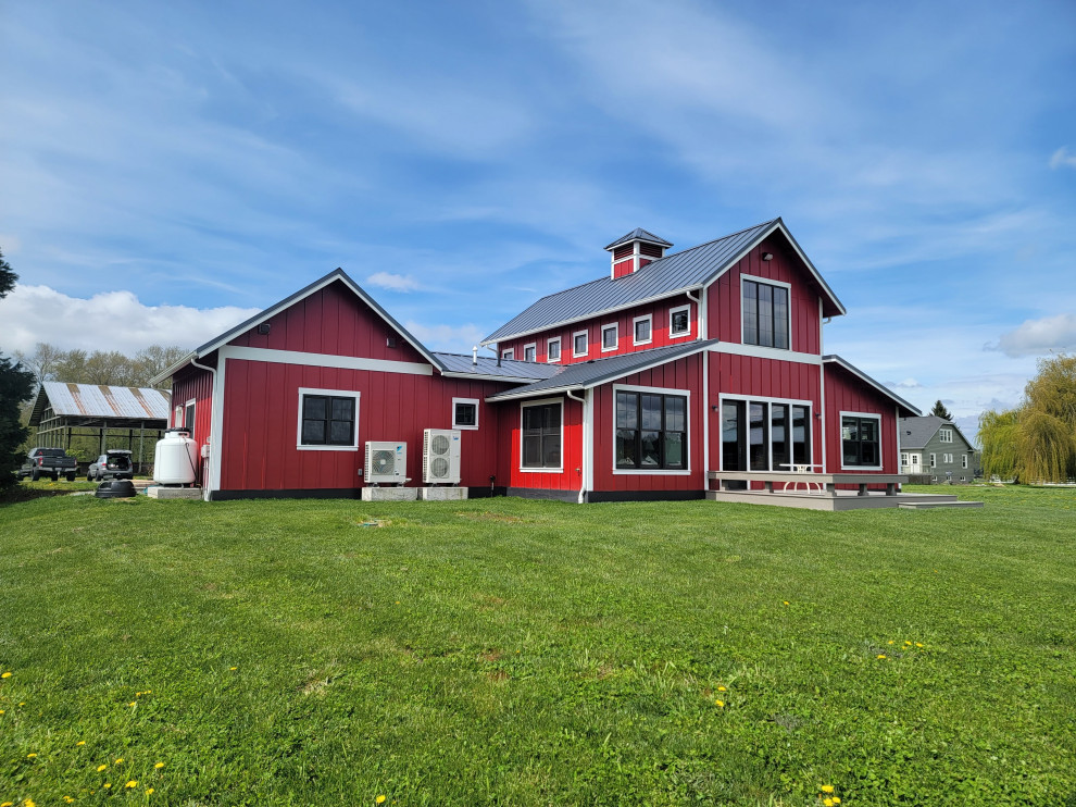 Inspiration pour une grande façade de maison rouge rustique en panneau de béton fibré et planches et couvre-joints à un étage avec un toit à deux pans, un toit en métal et un toit gris.