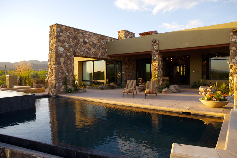 Large contemporary backyard rectangular lap pool in Phoenix with a hot tub and natural stone pavers.