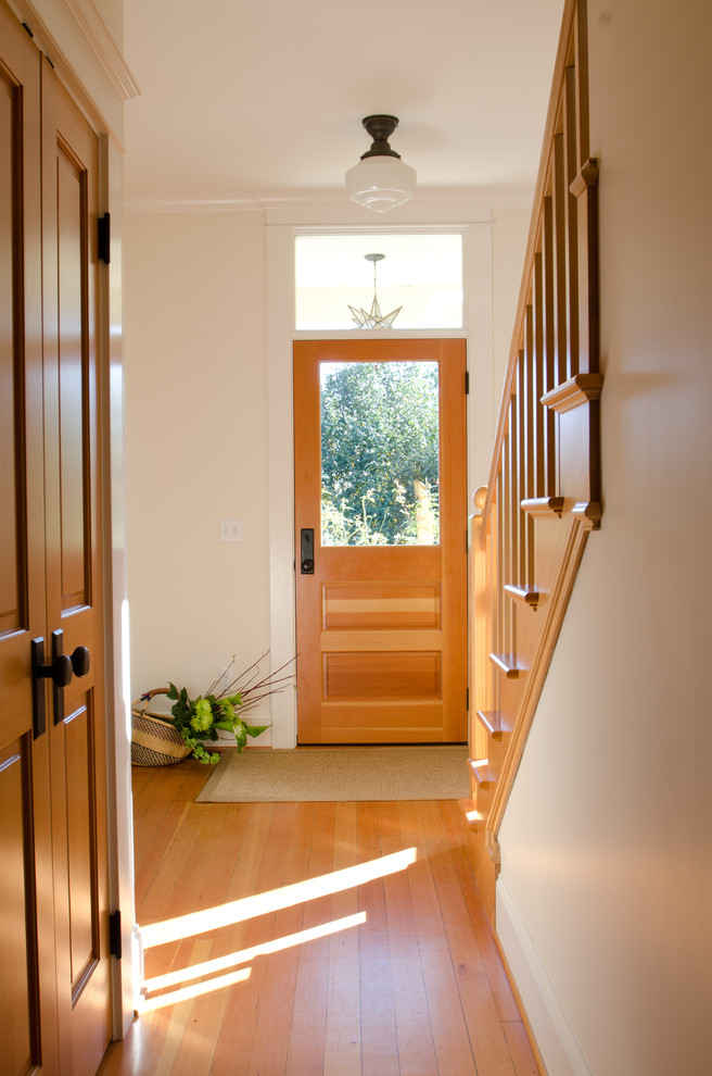 This is an example of a traditional hallway in Portland with white walls, medium hardwood floors and orange floor.