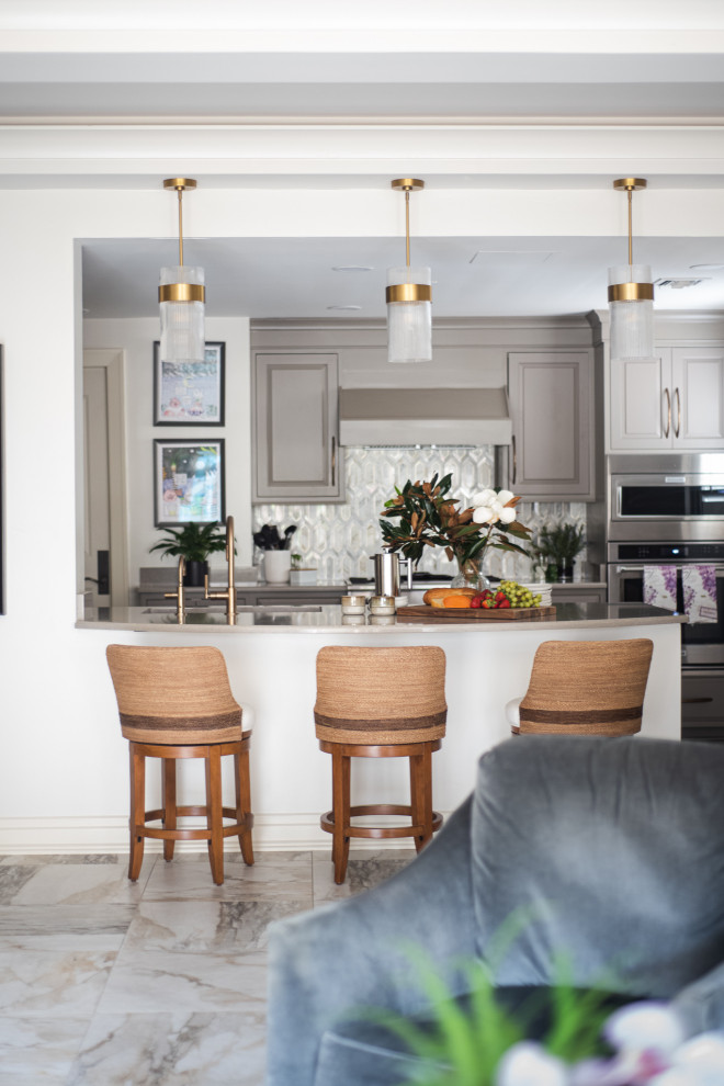 Example of a small u-shaped enclosed kitchen design with beige cabinets, white backsplash, stainless steel appliances, a peninsula and beige countertops