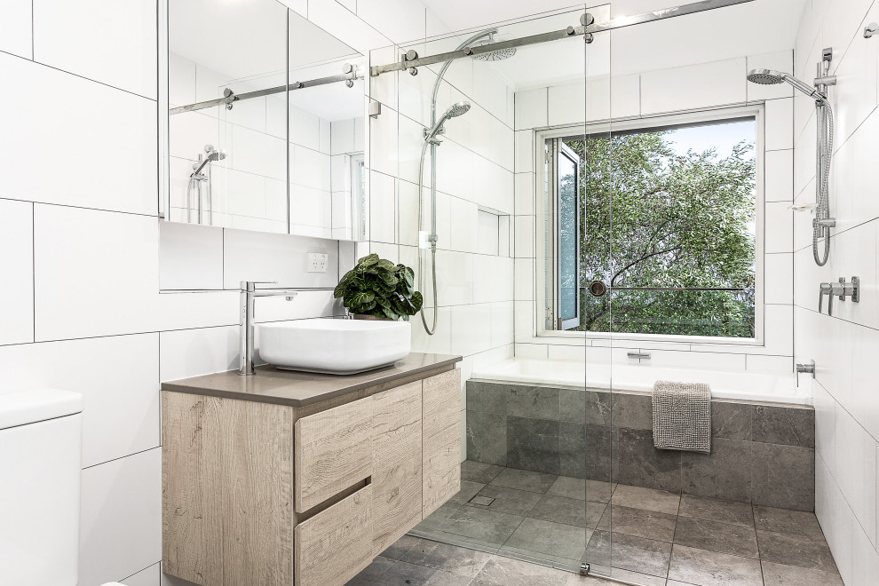 Contemporary wet room bathroom in Sydney with flat-panel cabinets, light wood cabinets, an alcove tub, gray tile, white tile, a vessel sink, grey floor, a sliding shower screen, grey benchtops, a single vanity and a floating vanity.