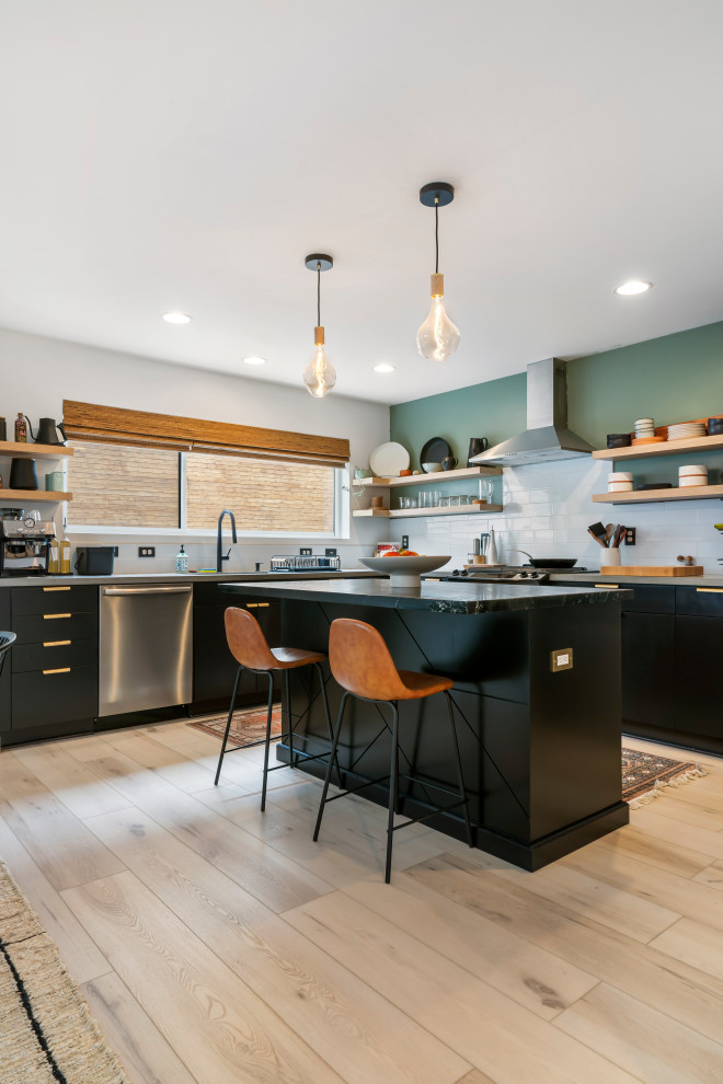 Photo of a large midcentury l-shaped kitchen/diner in Seattle with a built-in sink, flat-panel cabinets, black cabinets, marble worktops, white splashback, ceramic splashback, stainless steel appliances, vinyl flooring, an island, beige floors and grey worktops.