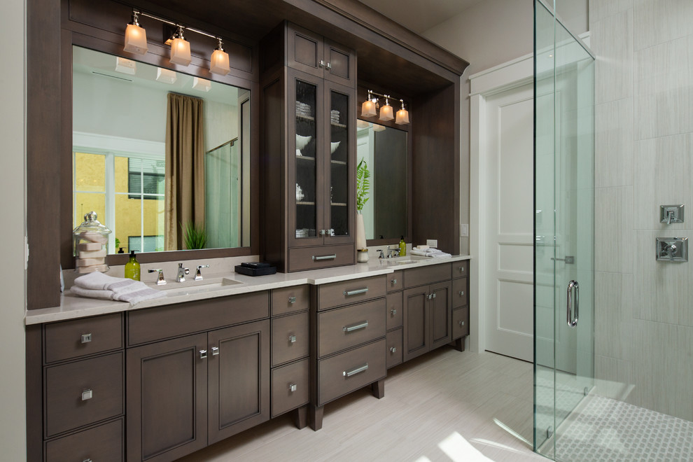 Inspiration for a beach style master bathroom in Miami with dark wood cabinets, a curbless shower, gray tile, beige walls, an undermount sink, beige floor, a hinged shower door, beige benchtops and shaker cabinets.