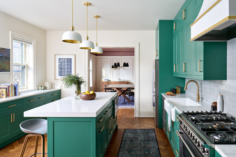 Example of a mid-sized transitional galley medium tone wood floor and brown floor enclosed kitchen design in Chicago with an undermount sink, recessed-panel cabinets, green cabinets, granite countertops, white backsplash, subway tile backsplash, stainless steel appliances, an island and white countertops