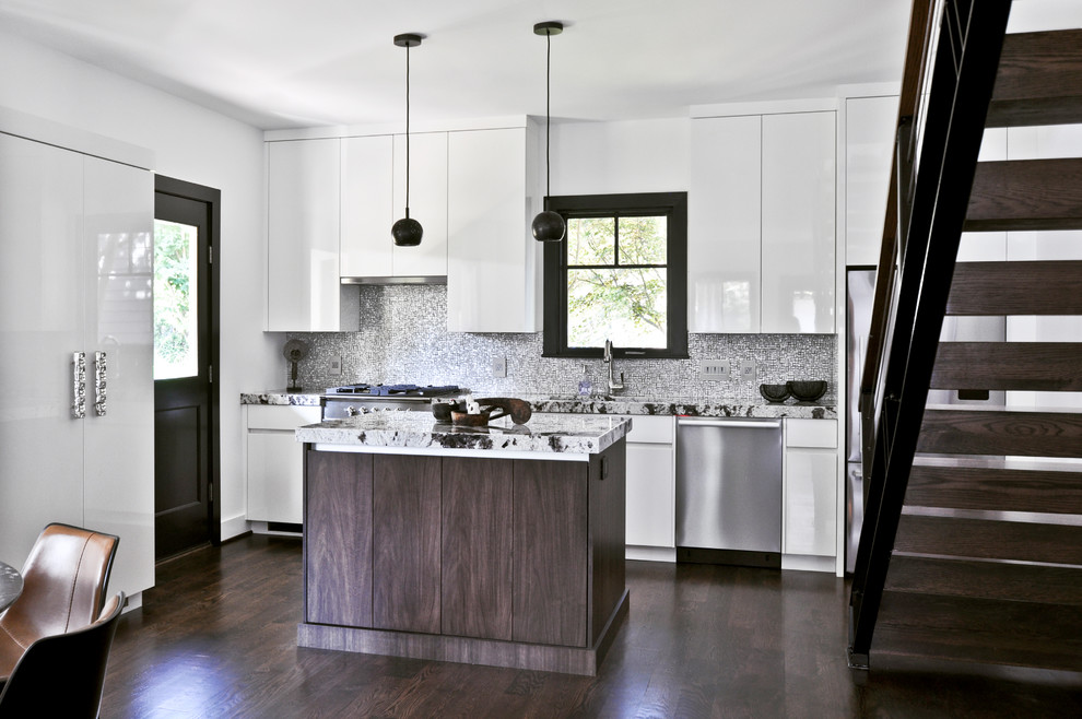 This is an example of a small contemporary galley open plan kitchen in Nashville with an undermount sink, flat-panel cabinets, white cabinets, granite benchtops, grey splashback, metal splashback, stainless steel appliances, dark hardwood floors, with island, multi-coloured floor and white benchtop.
