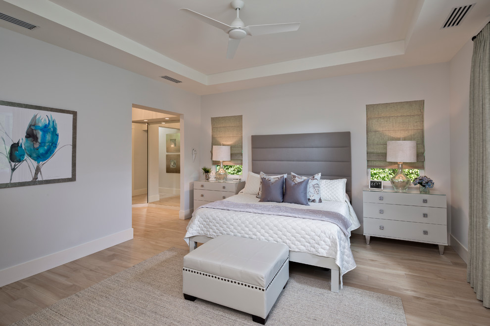 Design ideas for a large beach style master bedroom in Miami with grey walls and porcelain floors.
