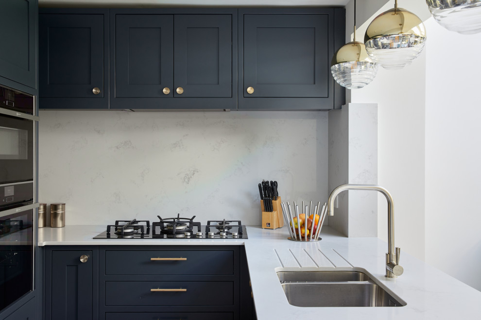 Exempel på ett litet klassiskt vit vitt kök, med luckor med infälld panel, blå skåp, bänkskiva i kvartsit och en köksö