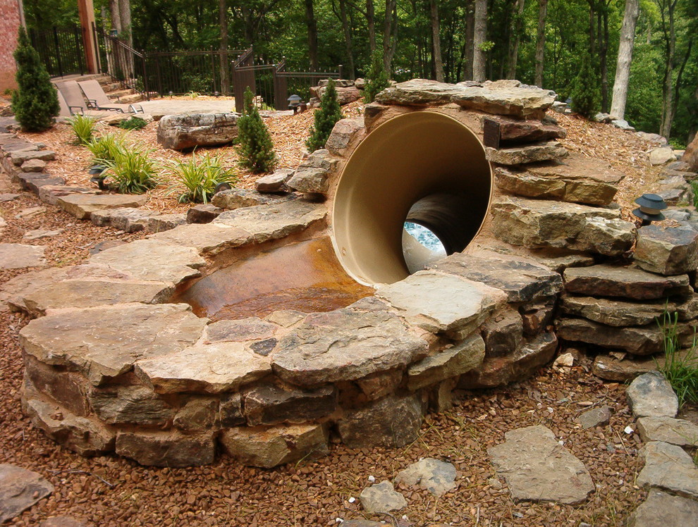Photo of a large country backyard custom-shaped natural pool in Other with a water slide and stamped concrete.