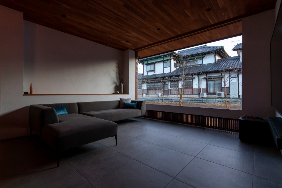Großes, Offenes Modernes Wohnzimmer mit grauer Wandfarbe, Porzellan-Bodenfliesen, schwarzem Boden, Holzdecke und Holzdielenwänden in Sonstige