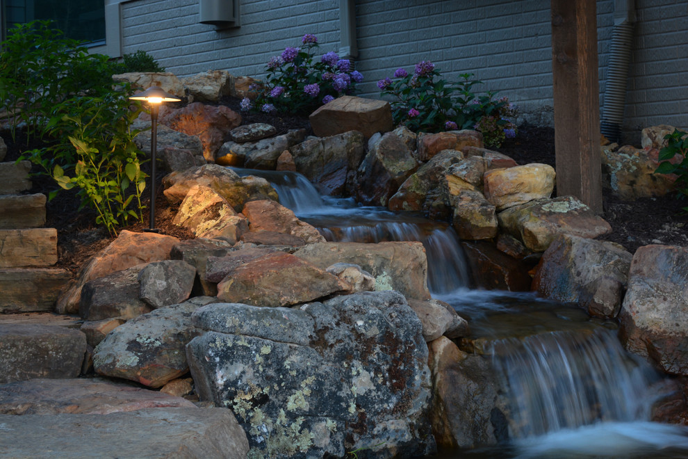 Large modern courtyard partial sun garden in Omaha with a water feature and natural stone pavers.