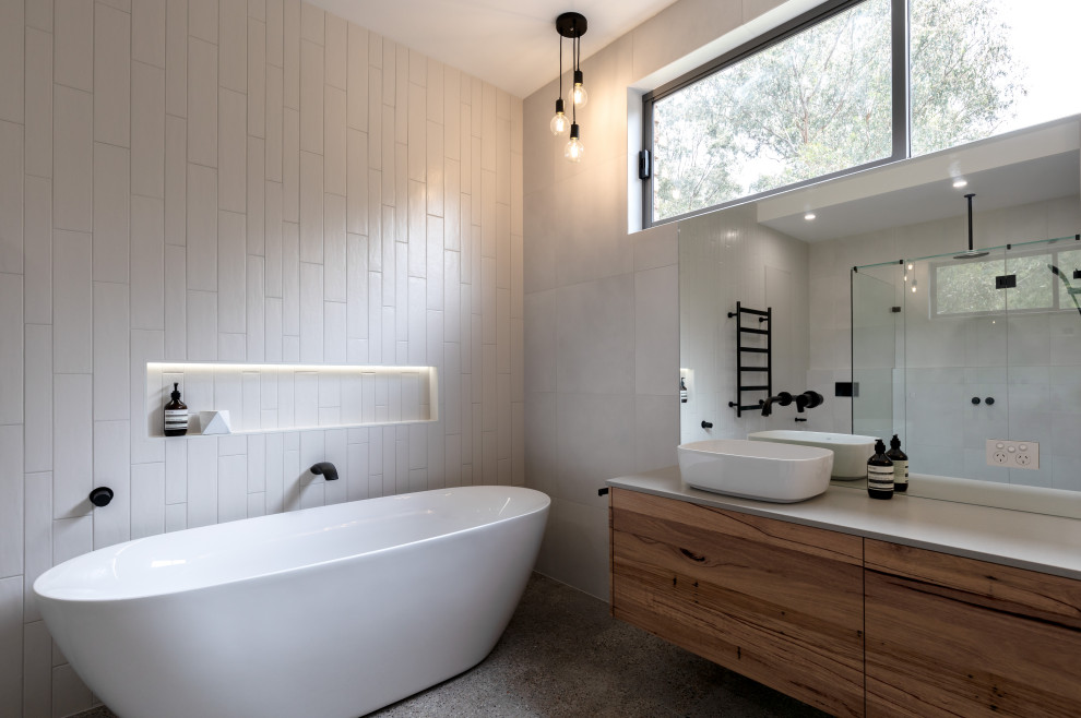 Design ideas for a mid-sized contemporary master bathroom in Melbourne with flat-panel cabinets, medium wood cabinets, a freestanding tub, an open shower, white tile, a vessel sink, grey floor, an open shower, grey benchtops, a niche, a double vanity and a built-in vanity.