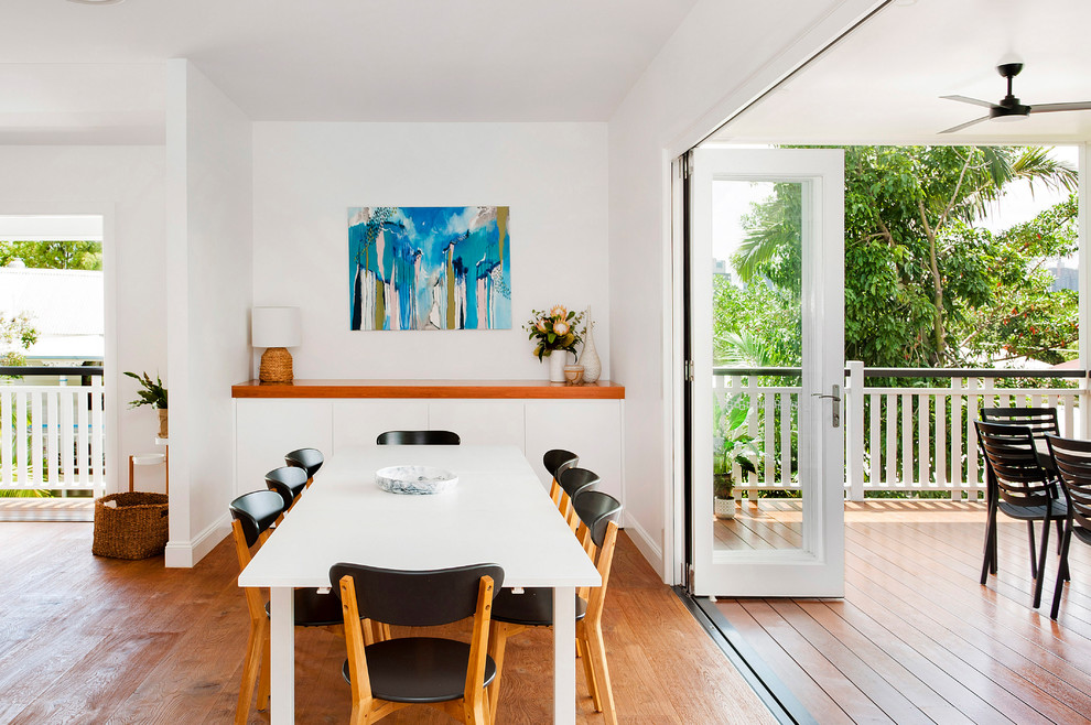 This is an example of a contemporary dining room in Brisbane with white walls, medium hardwood floors and brown floor.