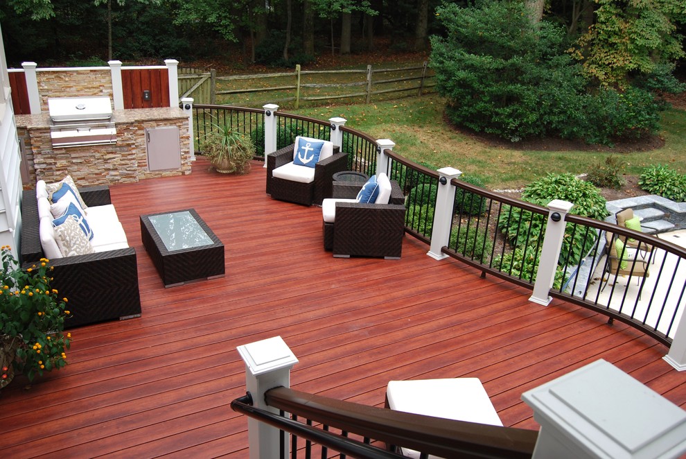 This is an example of a large traditional backyard deck in DC Metro with an outdoor kitchen and no cover.