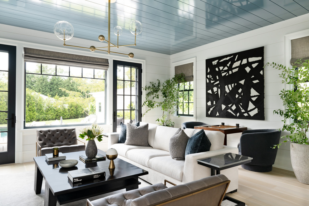 Photo of a transitional open concept living room in New York with white walls, light hardwood floors and beige floor.