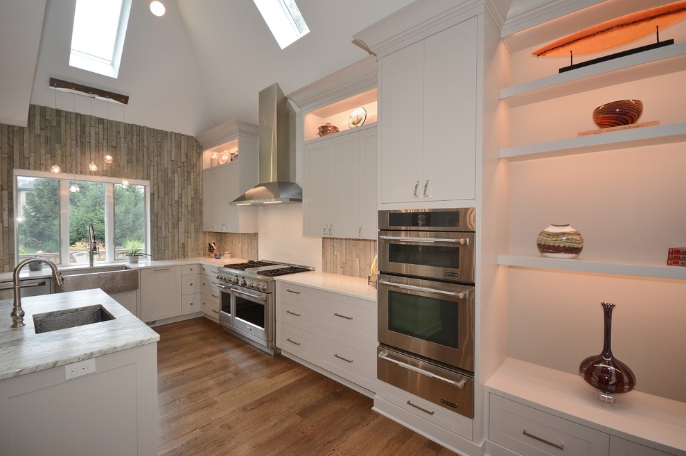 Example of a large transitional u-shaped dark wood floor and brown floor eat-in kitchen design with a farmhouse sink, recessed-panel cabinets, white cabinets, limestone countertops, beige backsplash, porcelain backsplash, stainless steel appliances, an island and gray countertops