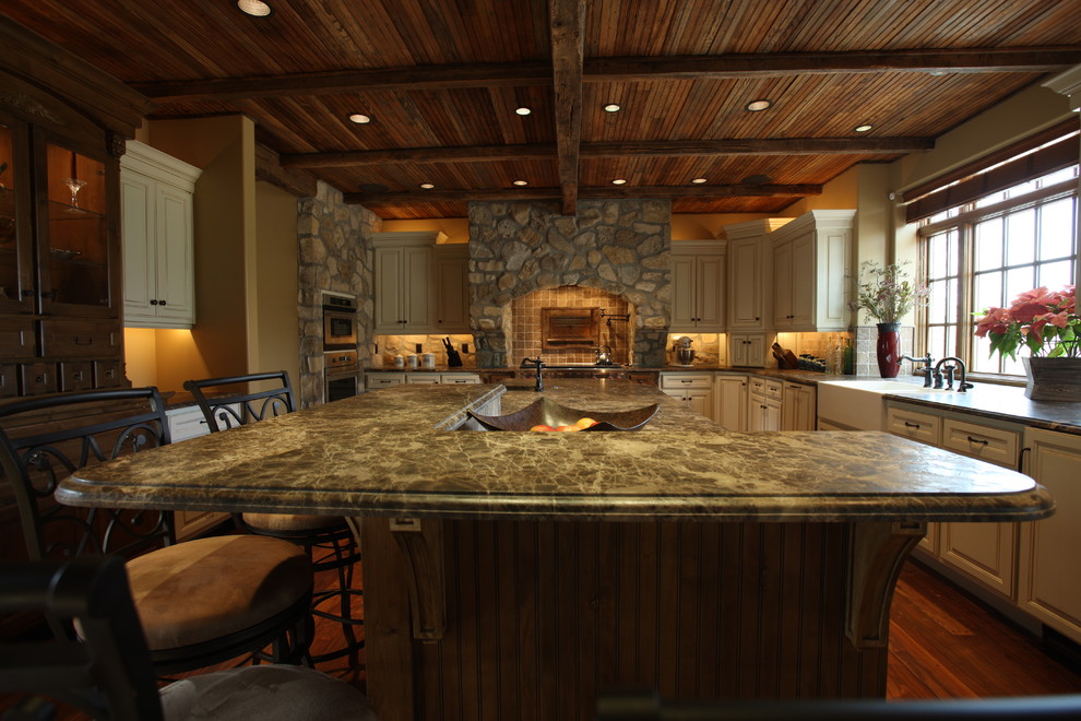 Inspiration for a large rustic l-shaped medium tone wood floor and brown floor open concept kitchen remodel with an undermount sink, white cabinets, granite countertops, brown backsplash, stone tile backsplash, stainless steel appliances and an island
