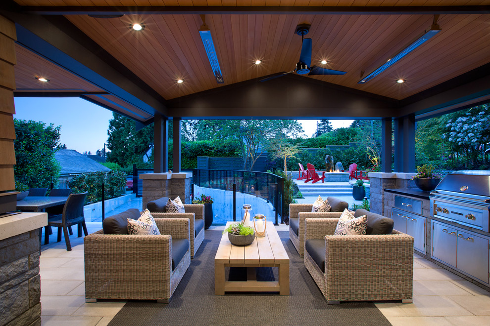 Inspiration for a large contemporary backyard patio in Vancouver with an outdoor kitchen, tile and a roof extension.