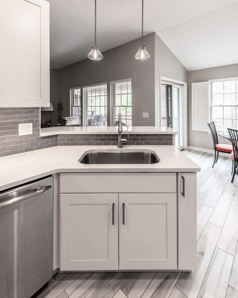 Inspiration for a mid-sized transitional galley porcelain tile and multicolored floor eat-in kitchen remodel with an undermount sink, recessed-panel cabinets, white cabinets, quartz countertops, gray backsplash, ceramic backsplash, stainless steel appliances, a peninsula and white countertops