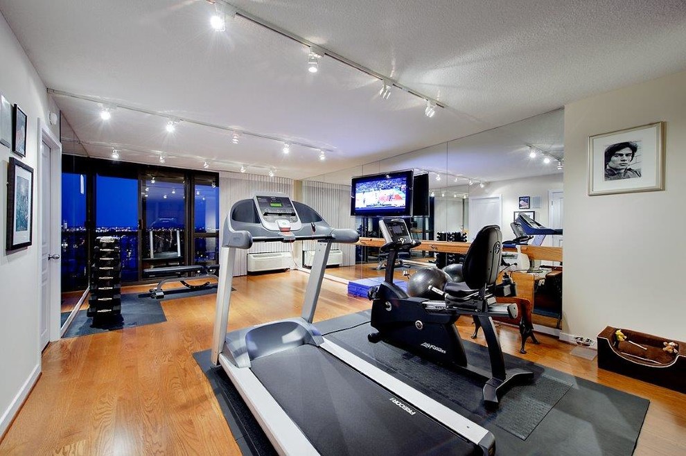 Expansive contemporary multipurpose gym in Philadelphia with grey walls and medium hardwood floors.