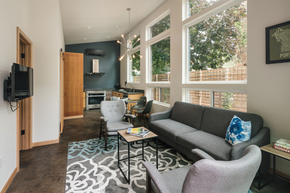 Photo of a small modern open concept family room in Portland with white walls, concrete floors, no fireplace, a wall-mounted tv and brown floor.