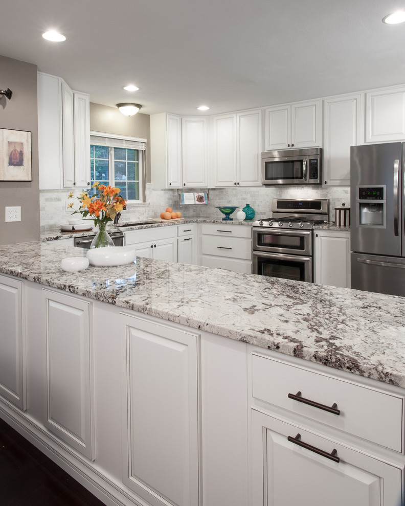 Mid-sized traditional u-shaped eat-in kitchen in St Louis with an undermount sink, raised-panel cabinets, white cabinets, granite benchtops, grey splashback, subway tile splashback, stainless steel appliances, dark hardwood floors and a peninsula.