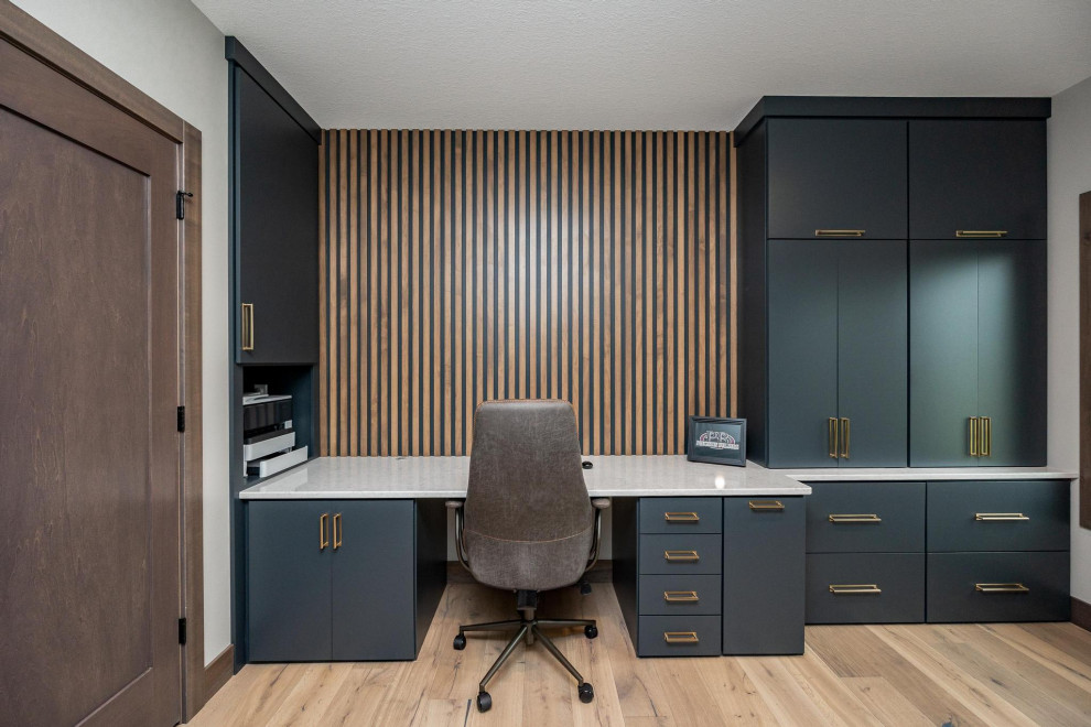 Diseño de despacho moderno con paredes grises, suelo de madera en tonos medios, escritorio empotrado, suelo marrón y madera