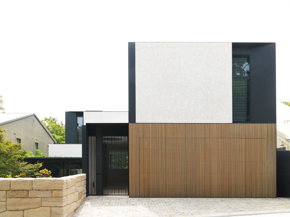 This is an example of a contemporary two-storey exterior in Sydney with mixed siding and a flat roof.
