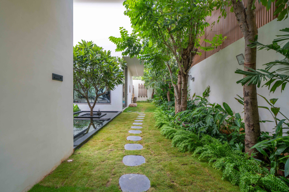 Design ideas for a tropical Partial Sun garden With a Garden Path and Natural Stone Pavers.