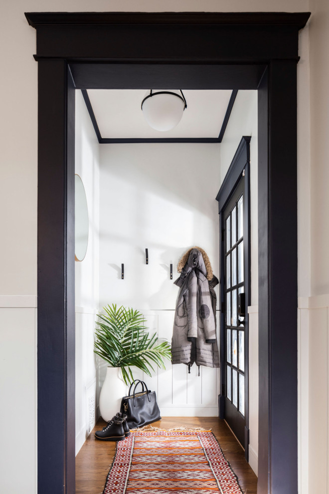 デンバーにある高級な小さなトランジショナルスタイルのおしゃれな玄関ロビー (白い壁、無垢フローリング、黒いドア、茶色い床、折り上げ天井) の写真