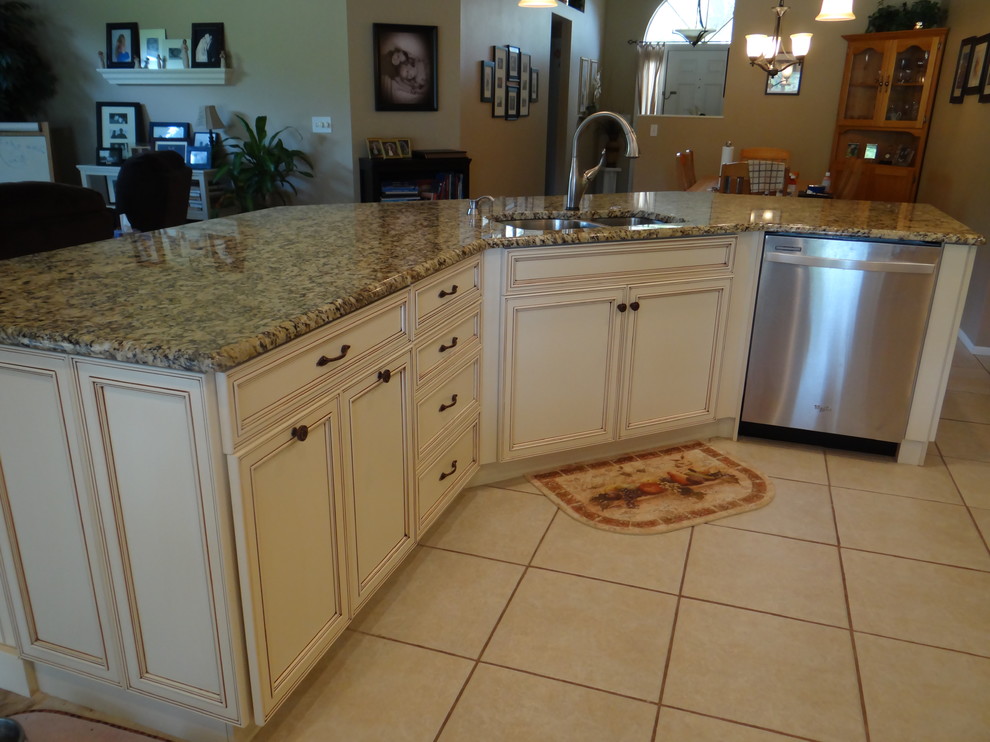 Photo of a large traditional u-shaped open plan kitchen in Tampa with an undermount sink, flat-panel cabinets, white cabinets, granite benchtops, multi-coloured splashback, stainless steel appliances, ceramic floors and with island.
