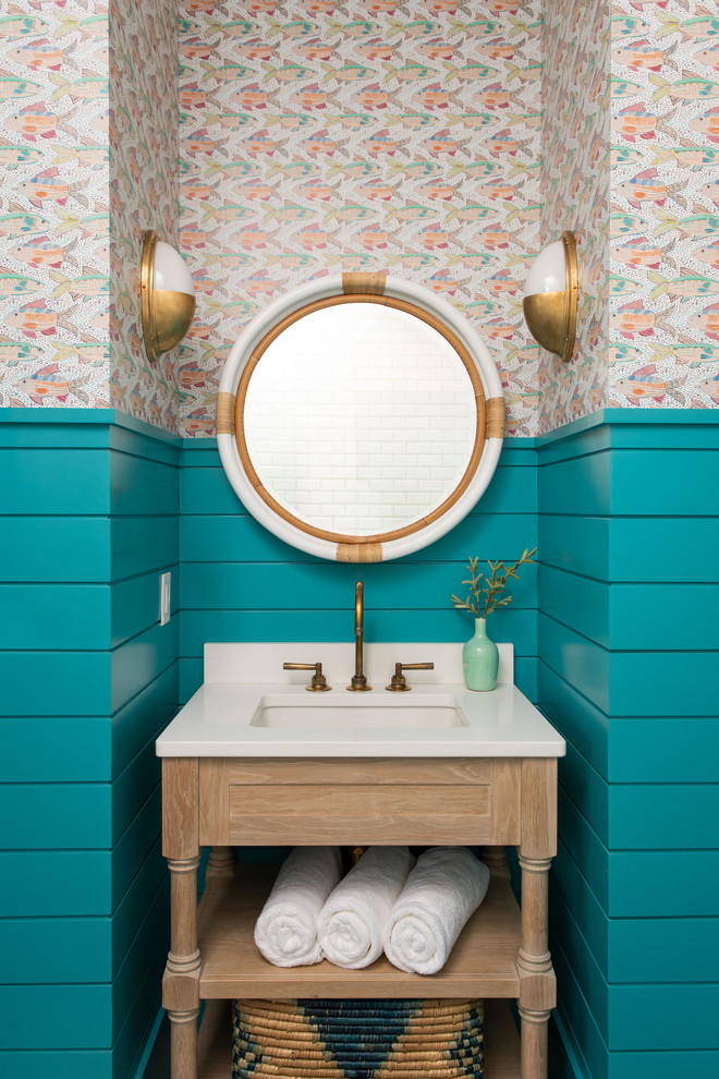 Photo of a beach style powder room in Other with furniture-like cabinets, light wood cabinets, multi-coloured walls, an undermount sink and beige benchtops.