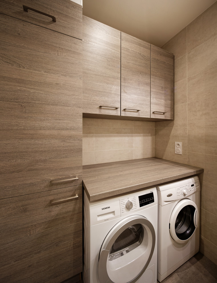 Inspiration for a medium sized contemporary single-wall utility room in Other with beaded cabinets, light wood cabinets, laminate countertops, beige walls and a side by side washer and dryer.