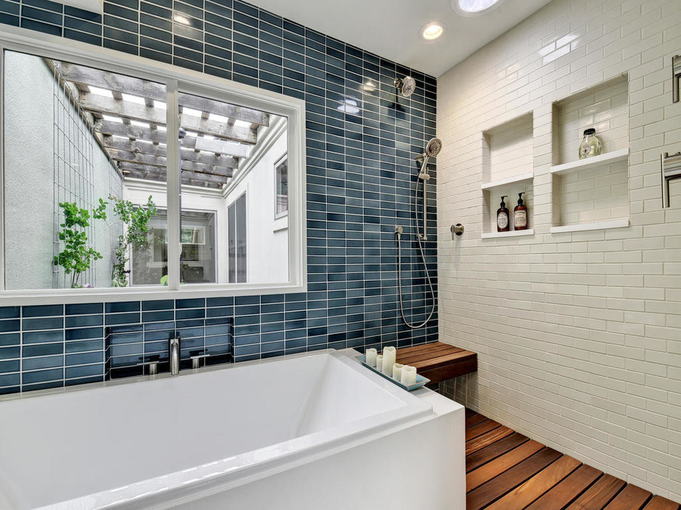 Mid-sized asian master bathroom in Austin with flat-panel cabinets, white cabinets, a drop-in tub, an open shower, blue tile, ceramic tile, blue walls, medium hardwood floors and wood benchtops.
